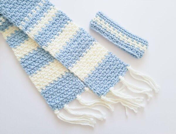 A blue and white scarf using the linen stitch with a matching headband on a white background.