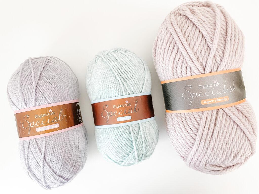A series of Stylecraft Special yarn balls in DK, Aran and Super Chunky weight.  The colours are pale lilac, aqua and biscuit brown.