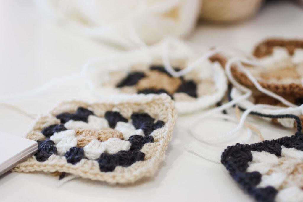 behind the scenes image of the not the high street poncho being designed featuring granny square samples 