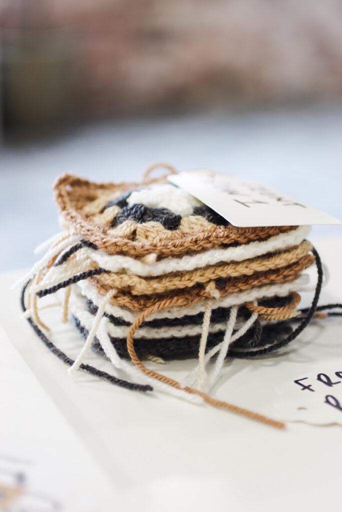 behind the scenes image of the not the high street poncho being designed featuring granny square samples 