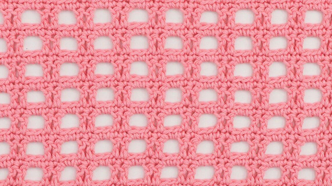 Pink crocheted mesh fabric with a square, openwork pattern